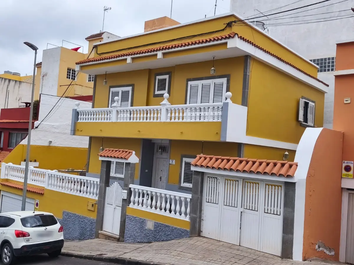 Fachada de vivienda pintada en amarillo y blanco en Arucas